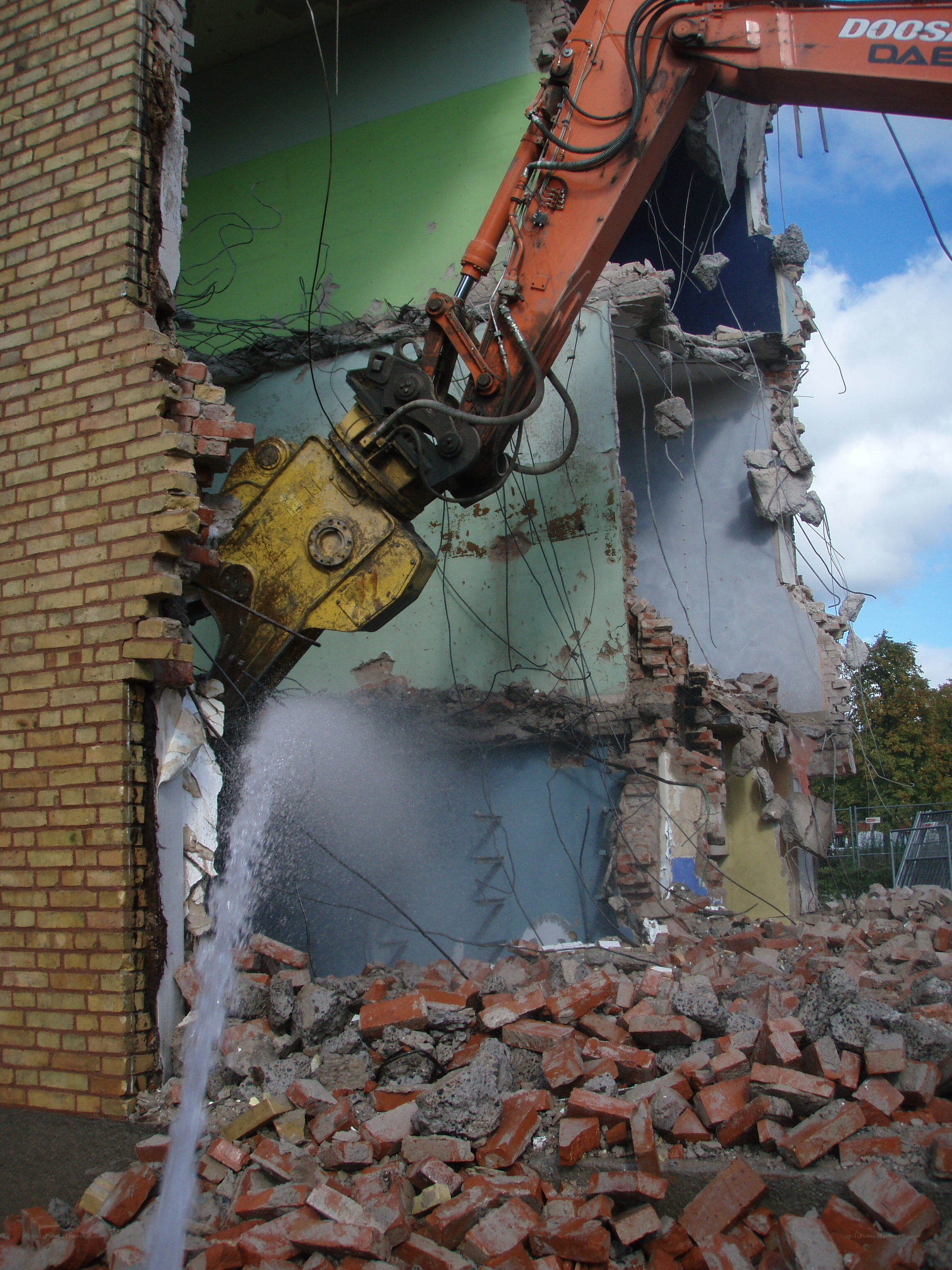 Excavator demolishing building