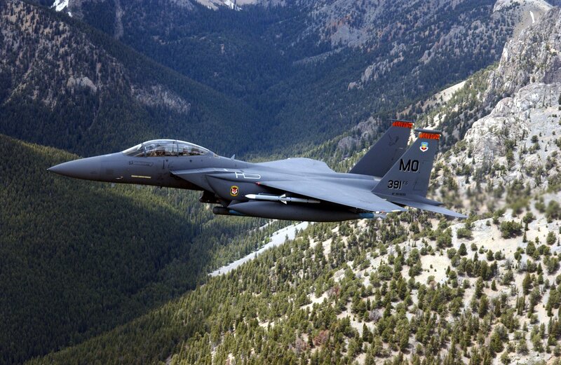 F-15E fighter jet over mountains