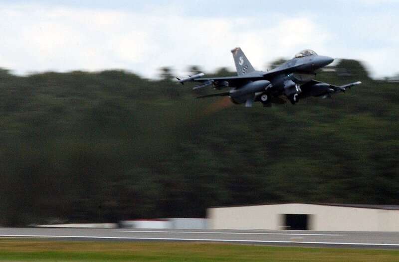 F-16 Fighter Jet — Gray, Dynamic, Afternoon, Photograph, Aircraft, Runway, Trees, Green