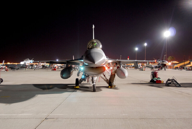 F-16 fighter jet on tarmac at night