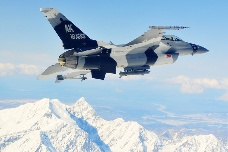 F-16 fighter jet over snowy mountains