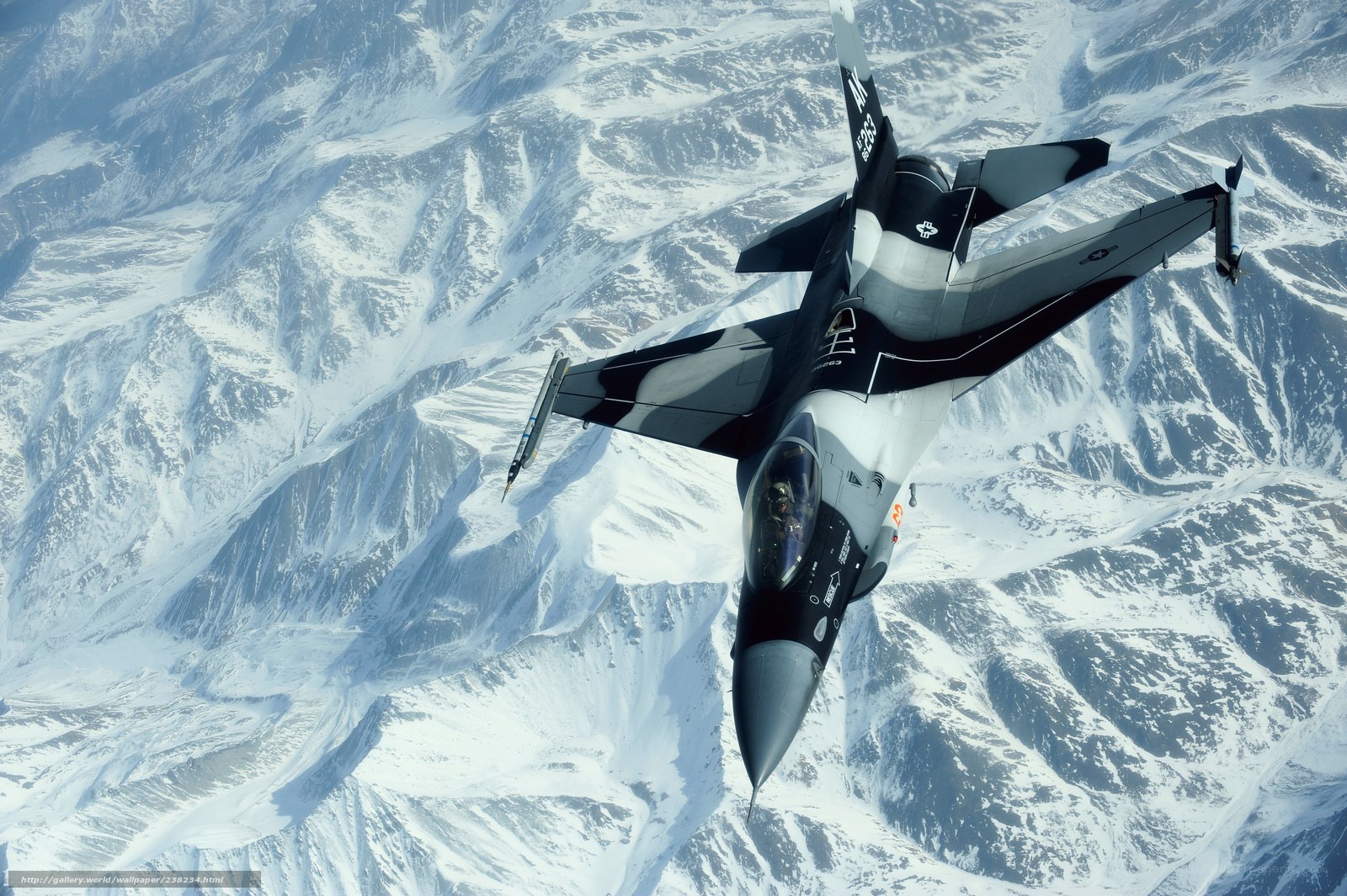 F-16 fighter jet over snowy mountains