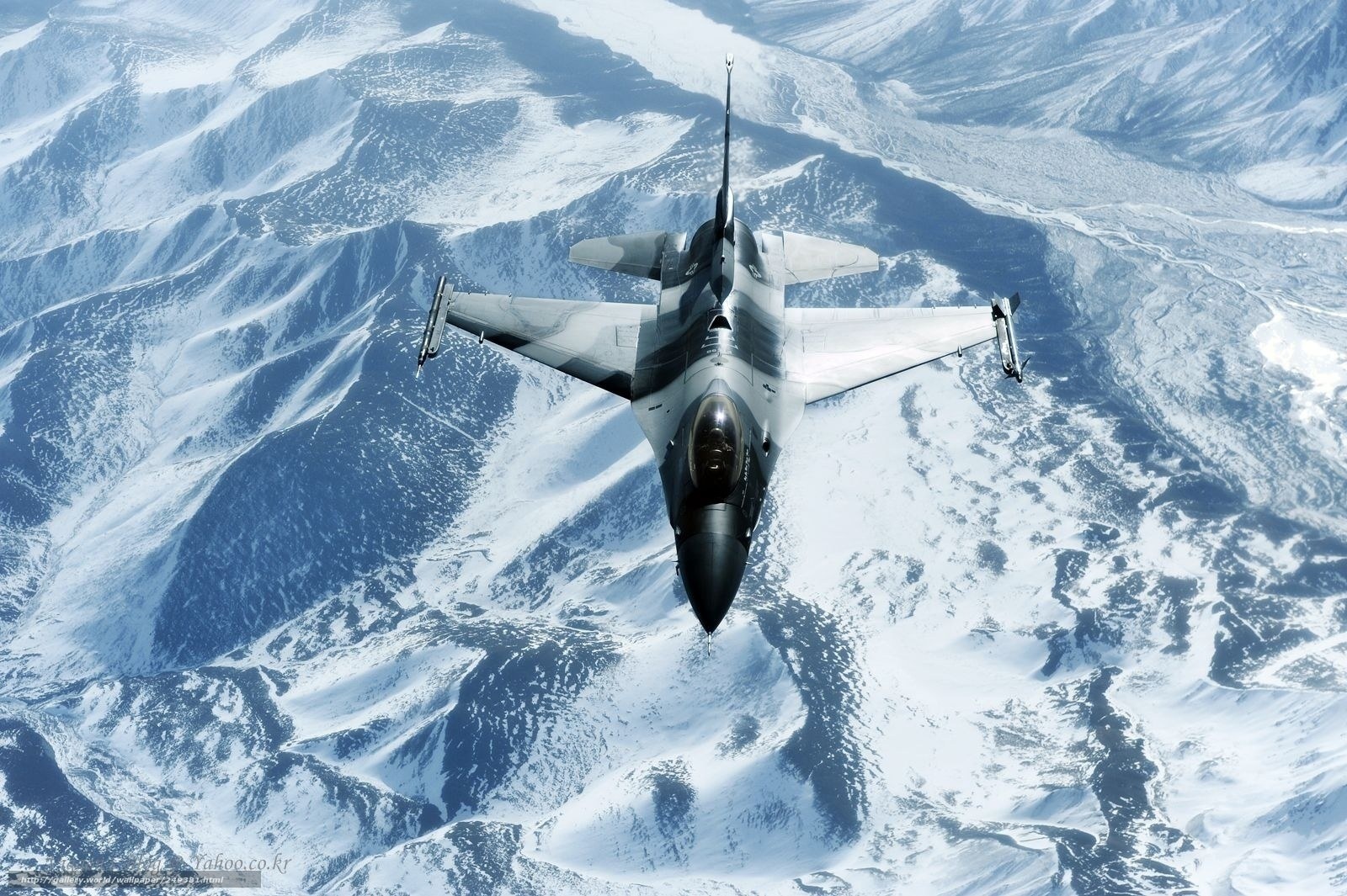 F-16 fighter jet over snowy mountains