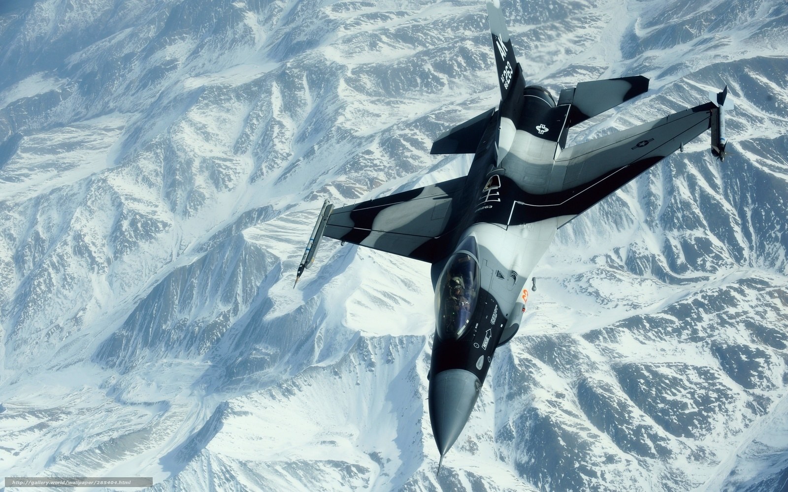 F-16 fighter jet over snowy mountains