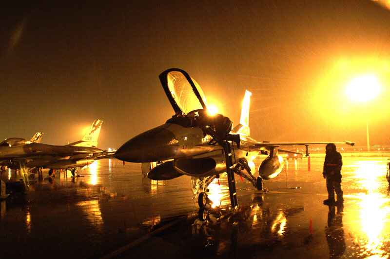 F-16 fighter jets on tarmac at night