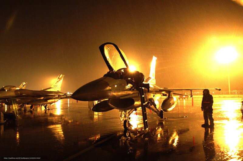 F-16 fighter jets on tarmac at night