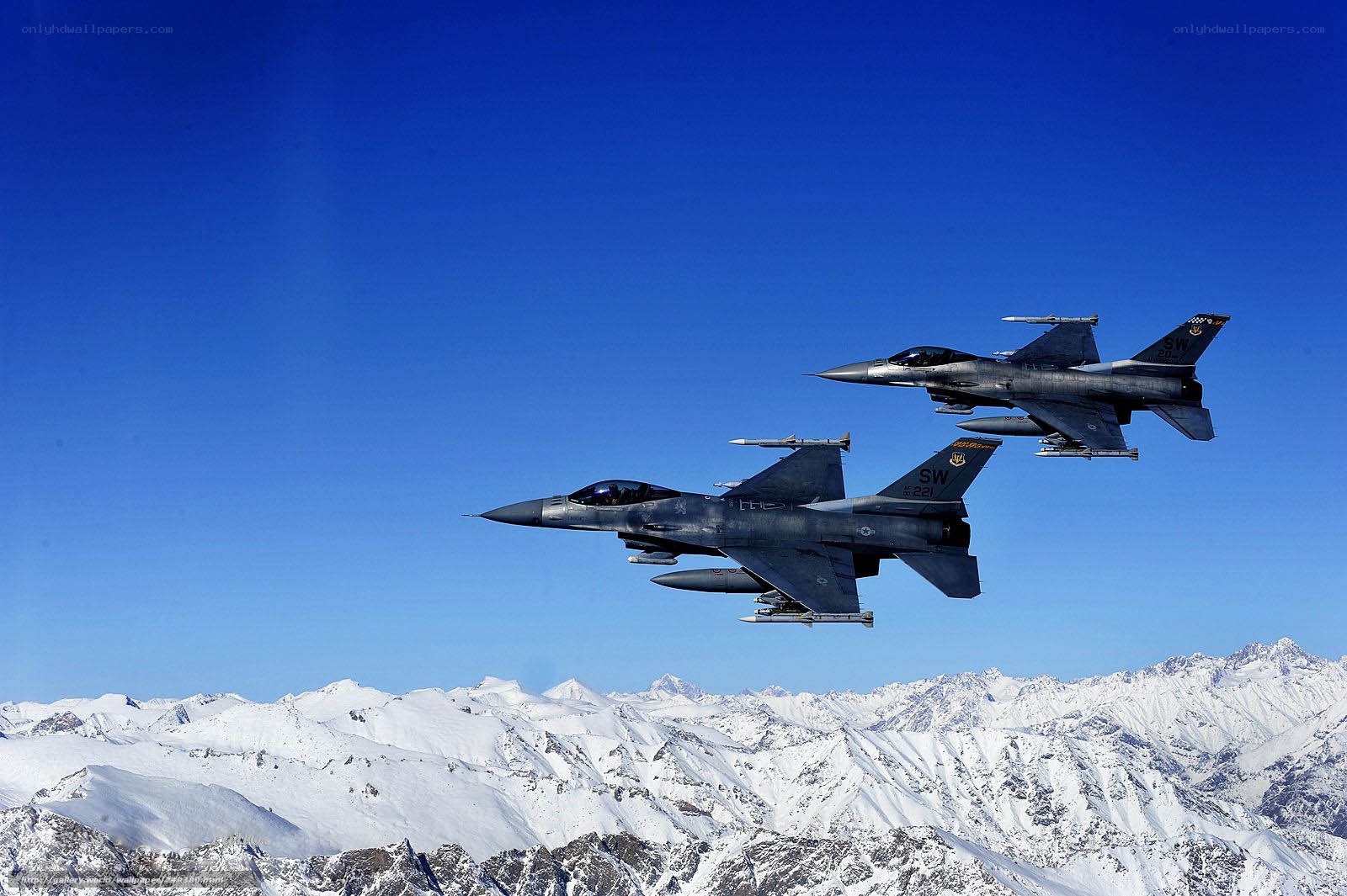 F-16 fighter jets over snowy mountains