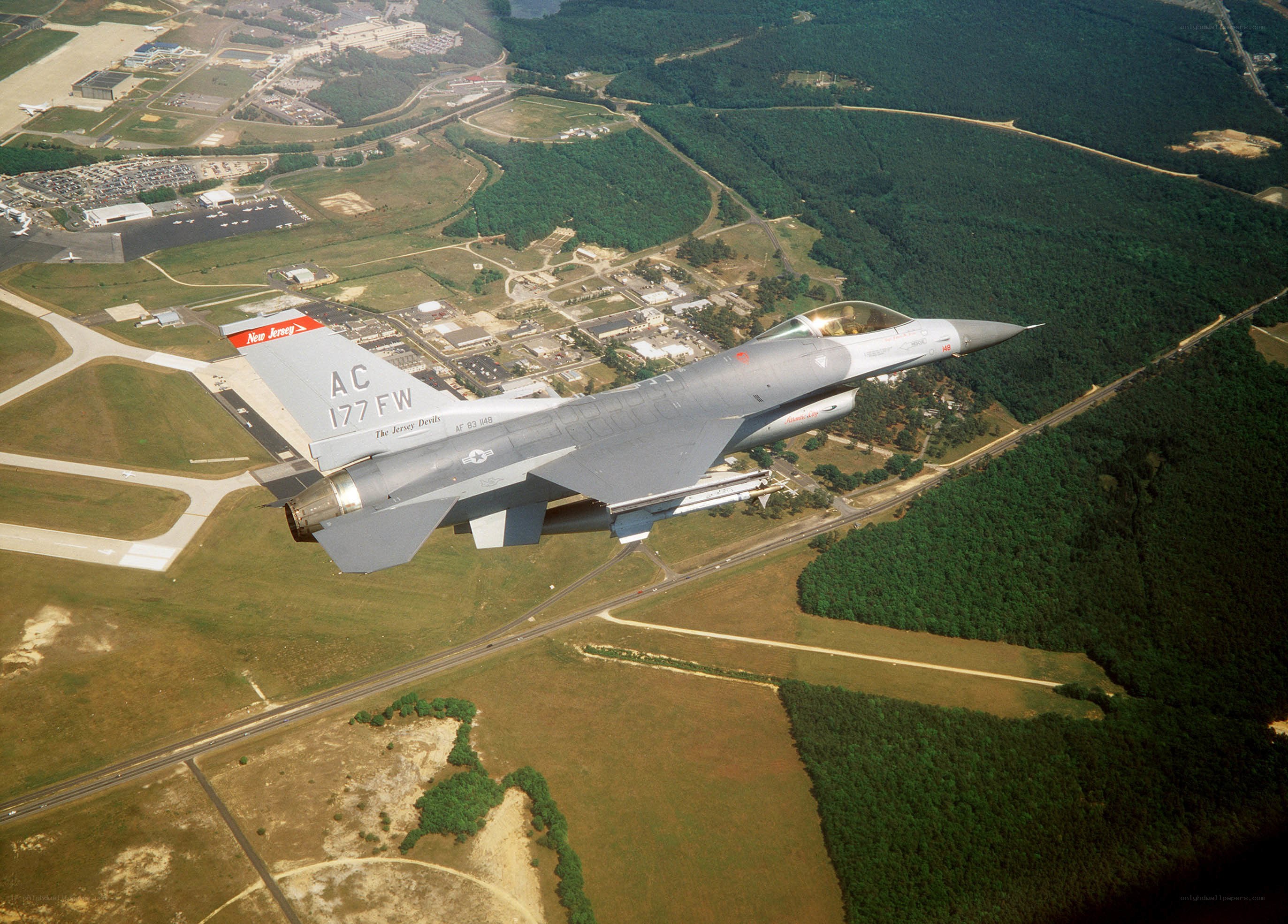 F-16 jet flying over airbase
