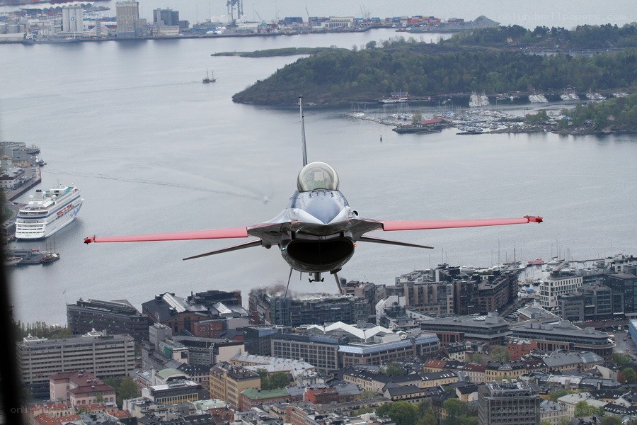 F-16 jet flying over city