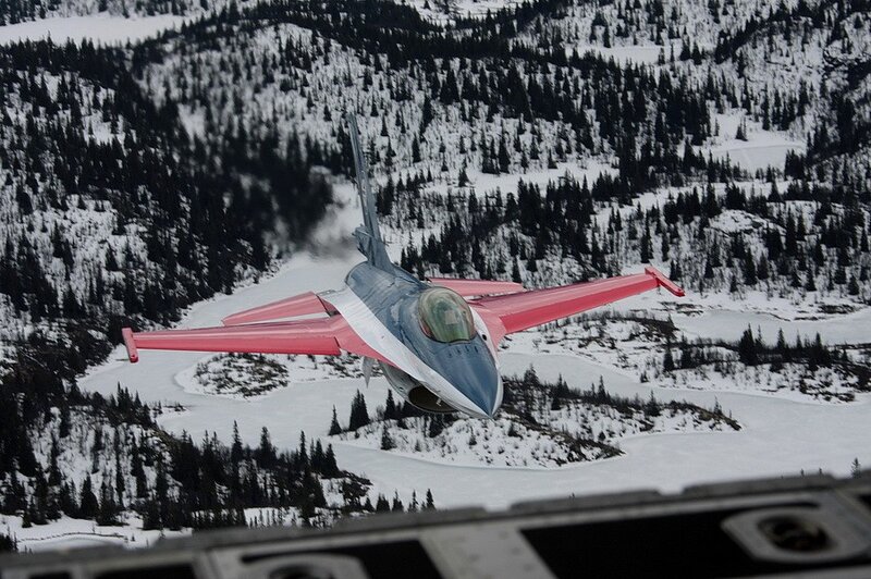 F-16 jet in flight over snowy mountains