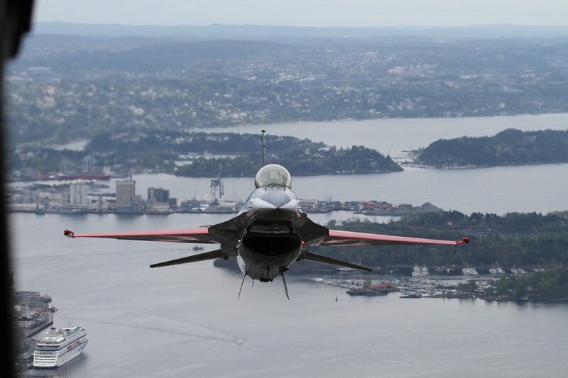 F-16 jet over coastal city