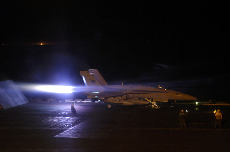 F-18 jet on aircraft carrier at night