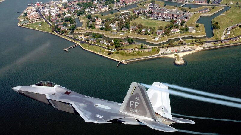 F-22 Raptor flying over a coastal fort