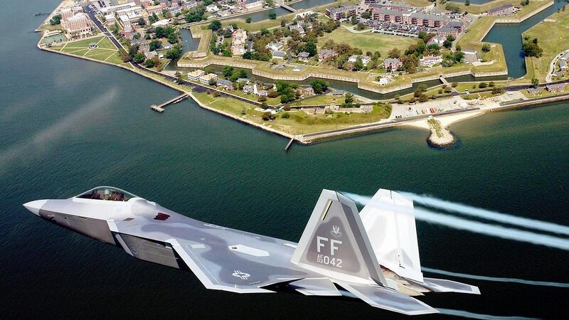F-22 Raptor flying over a coastal fort
