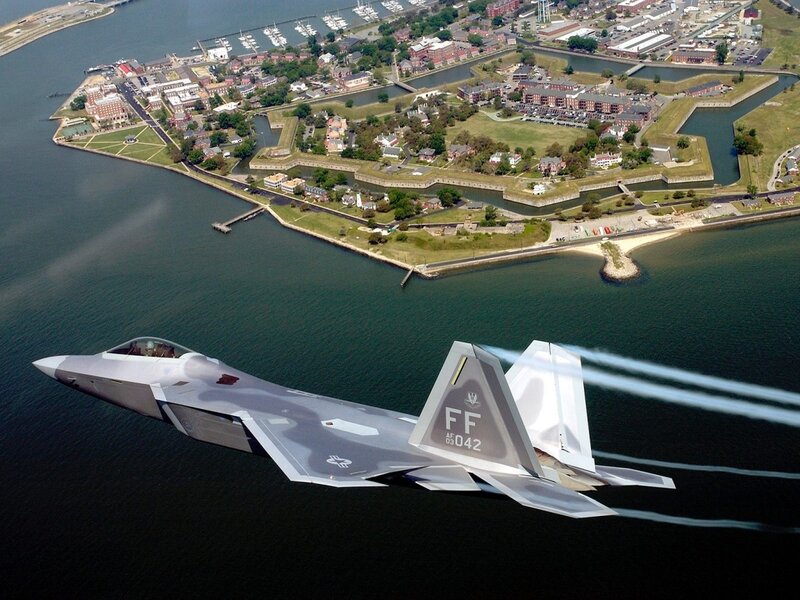 F-22 Raptor flying over a coastal fort