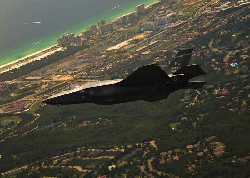 F-35 fighter jet over coastal city