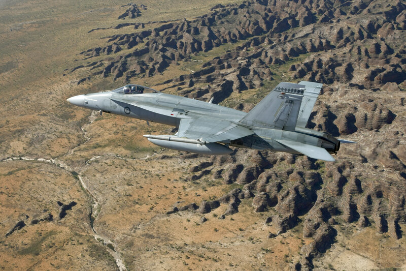 F/A-18 Hornet flying over rugged terrain