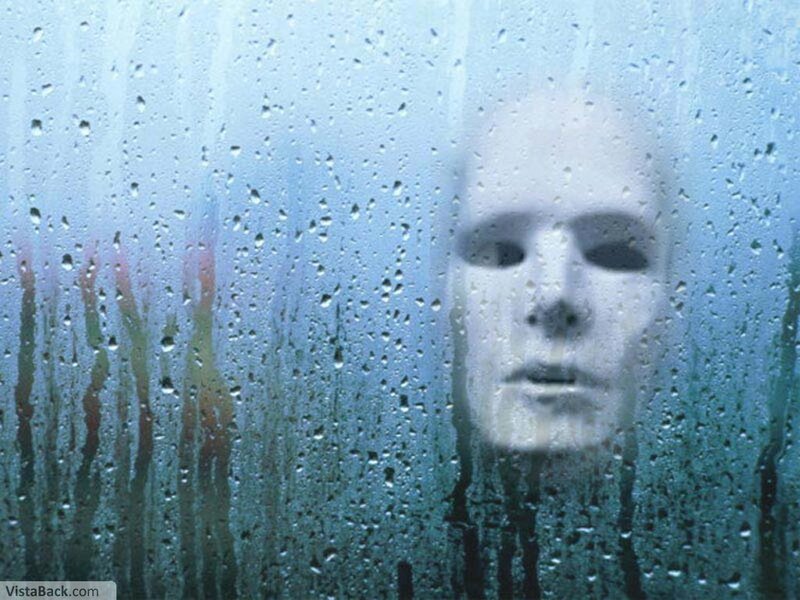 face behind rain-covered glass