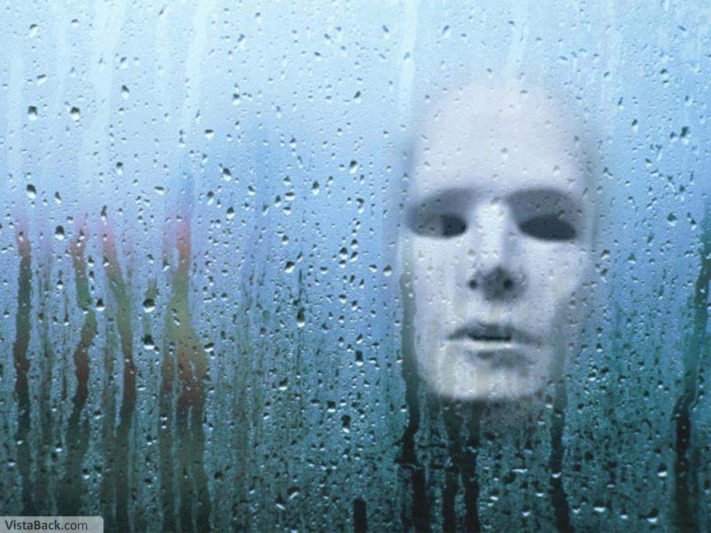face behind rain-covered glass