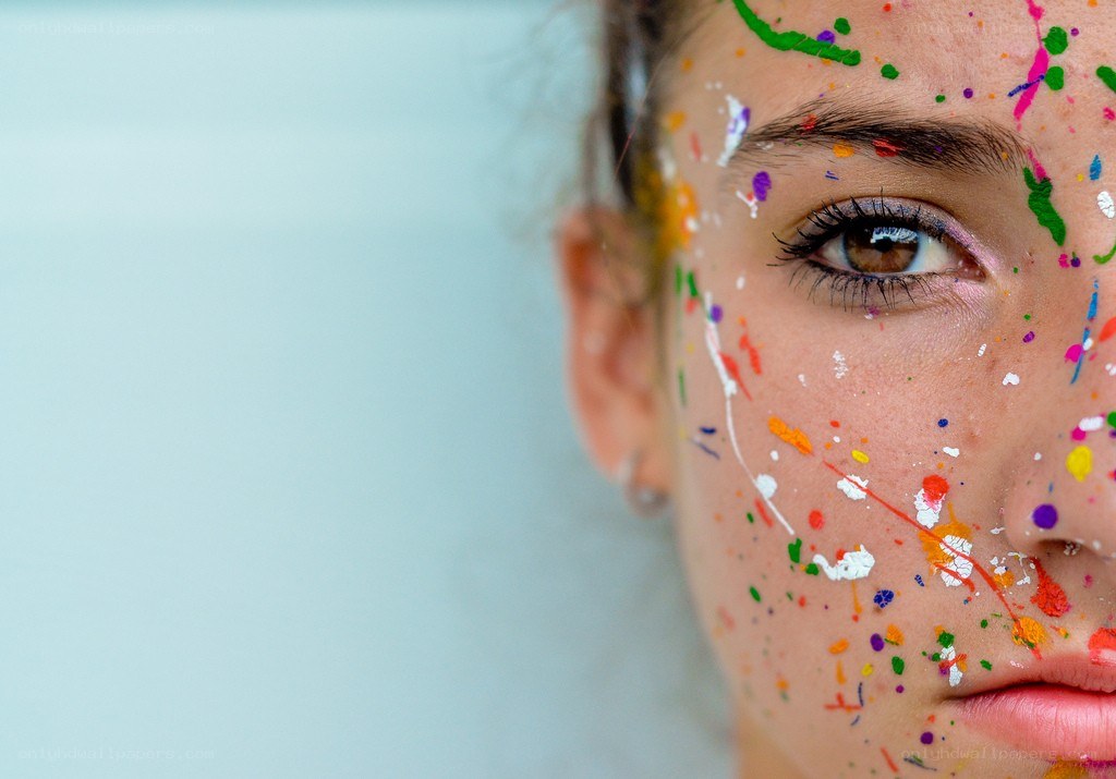 face with colorful paint splatters