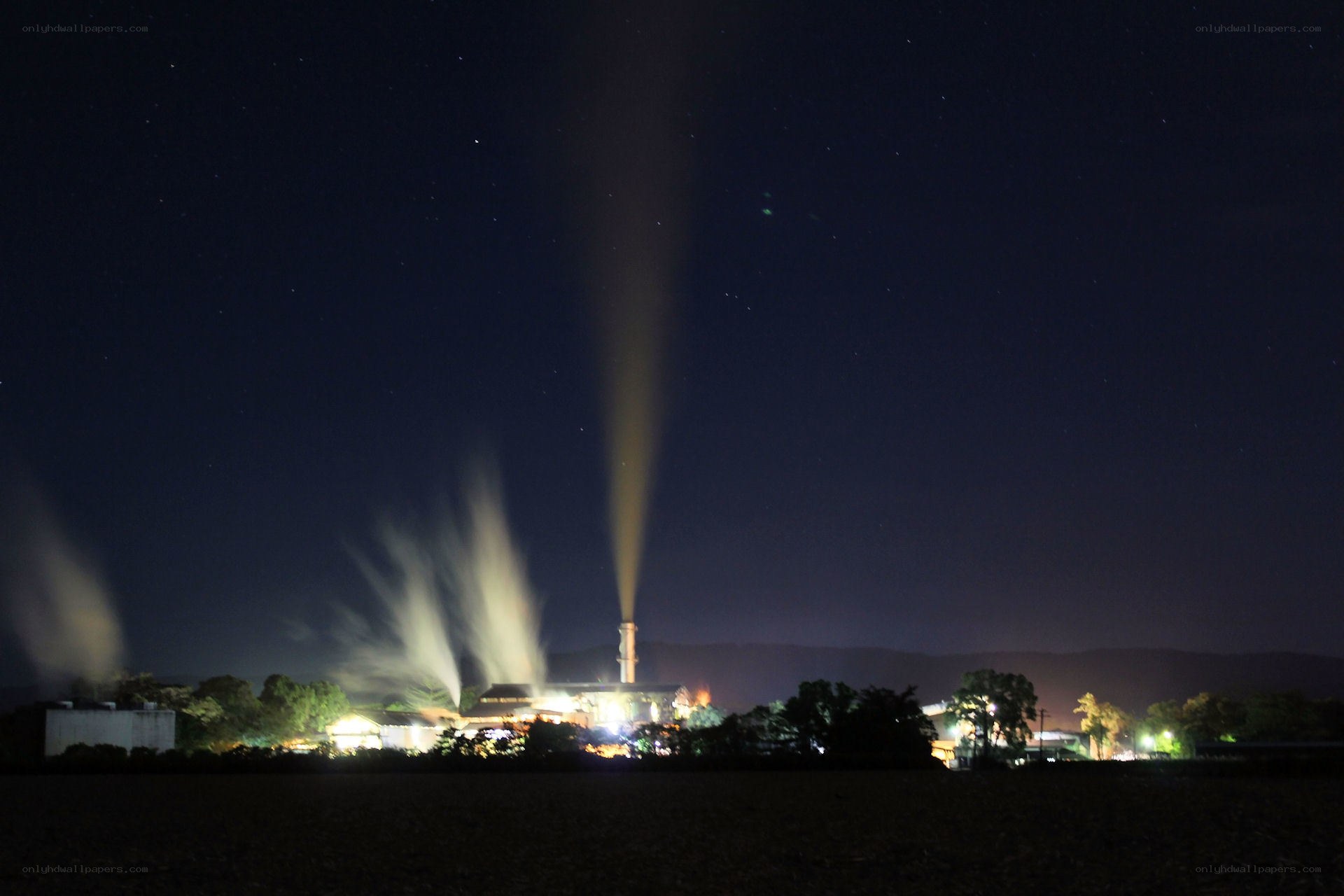 Factory at night with smoke