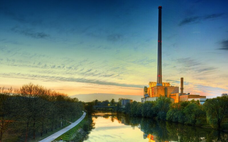 Factory by the river at sunset