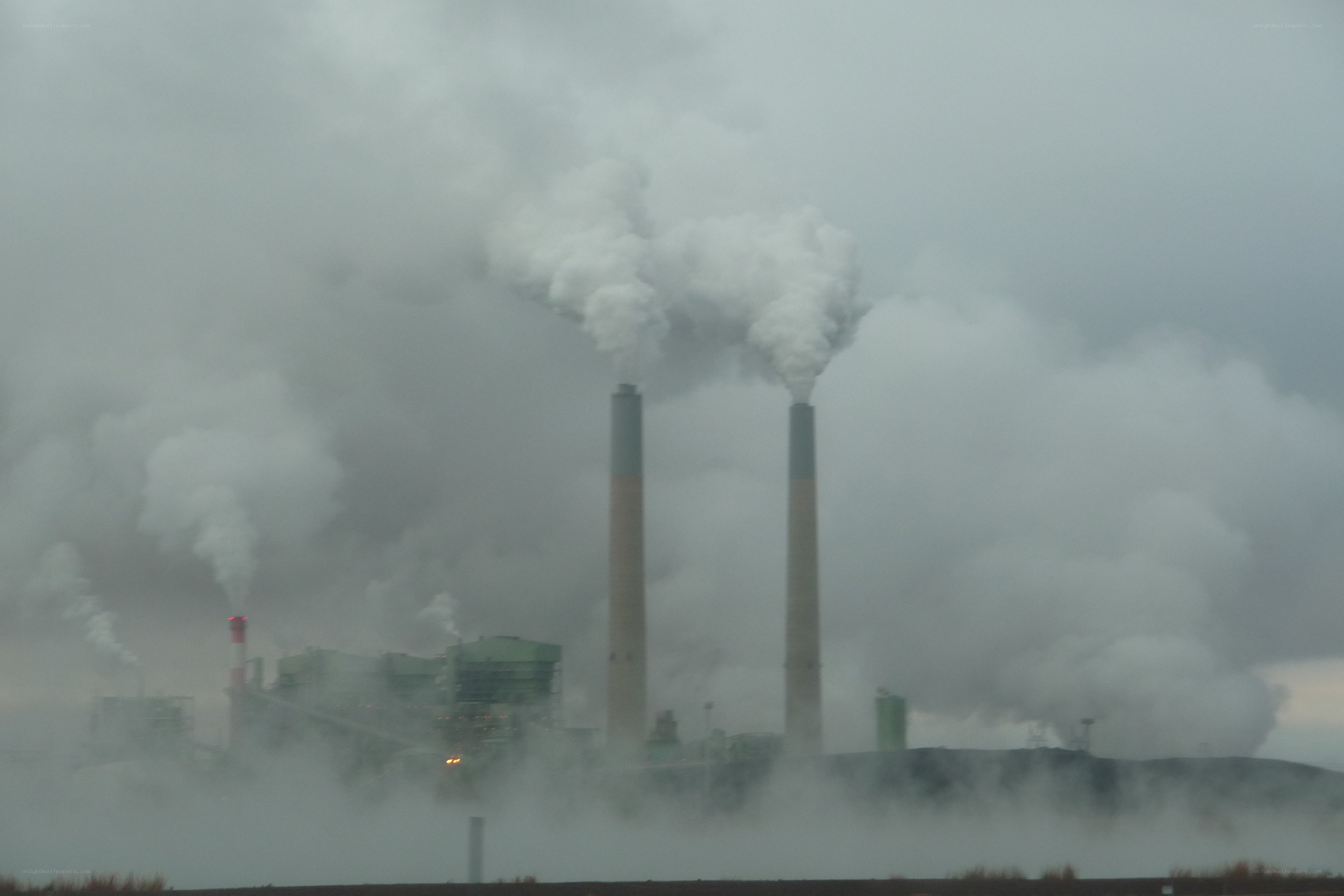 Factory with smokestacks emitting emissions