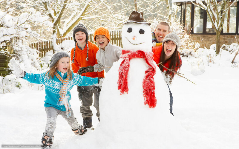 Family building snowman in garden