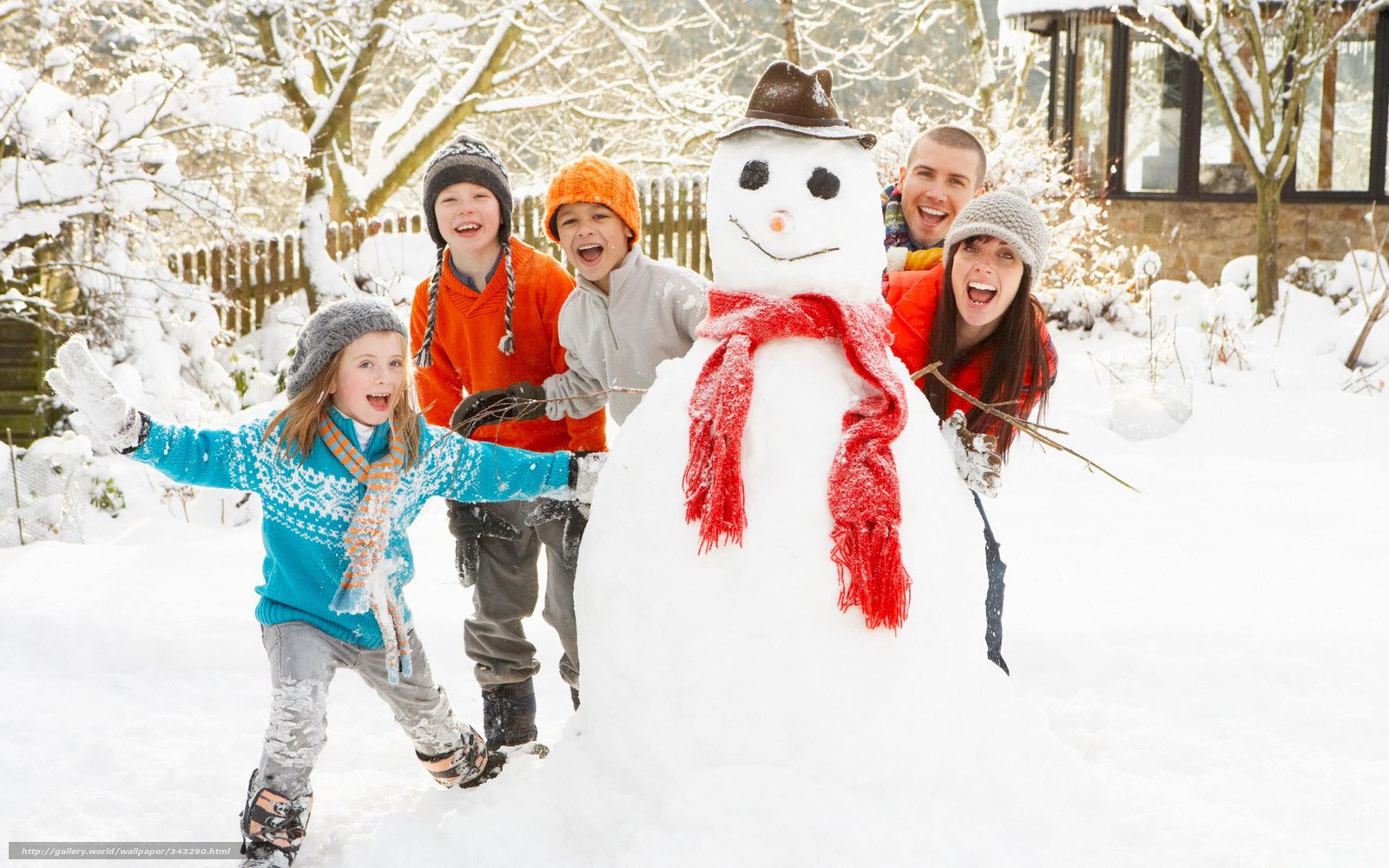 Family building snowman in garden