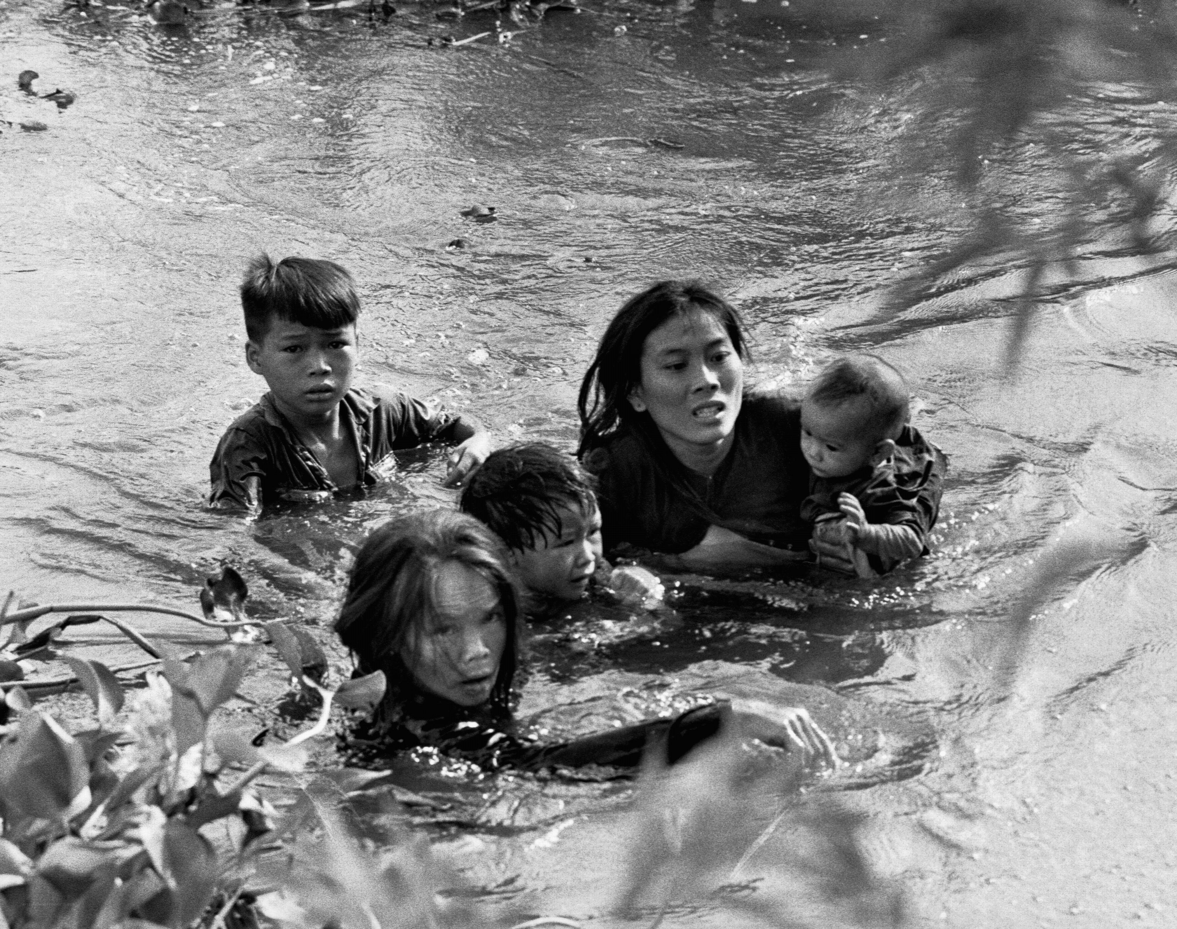 Family crossing river in flood