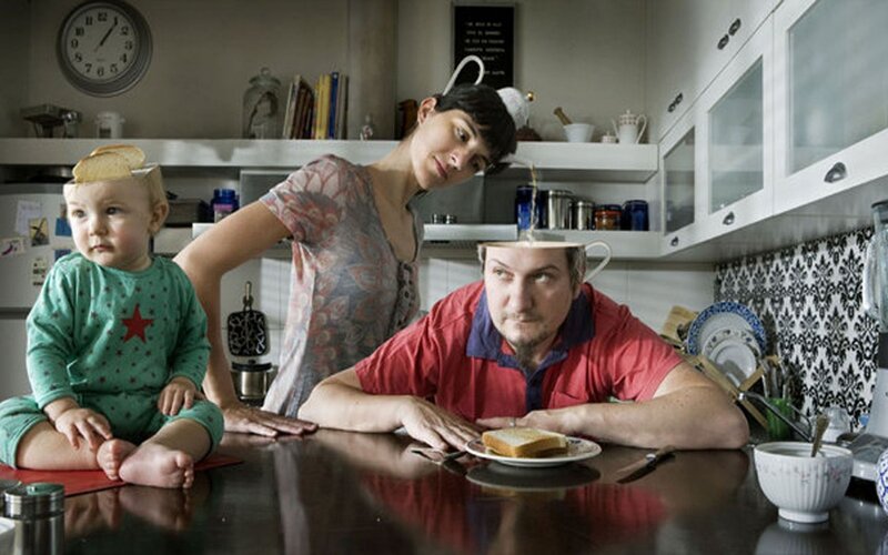 Family in kitchen with bread on heads