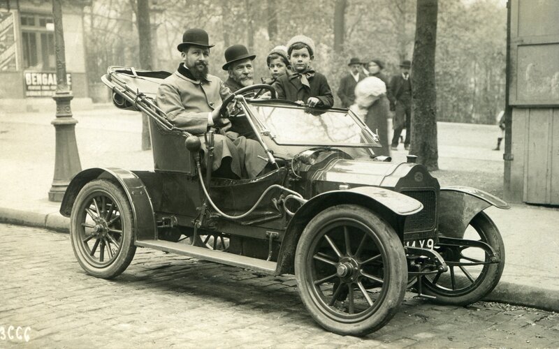 Family in vintage car on street
