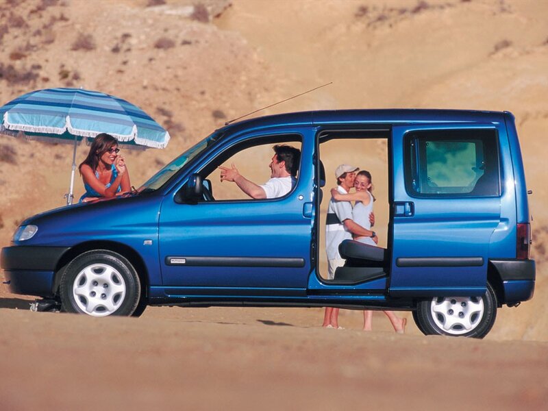 Family on beach with blue car