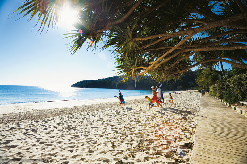 Family playing on sunny beach