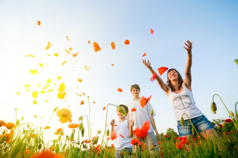 Family throwing flower petals in a field