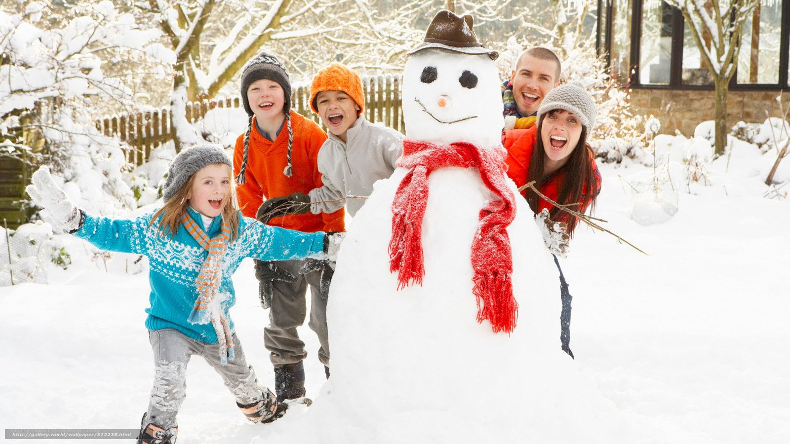 Family with snowman in snow