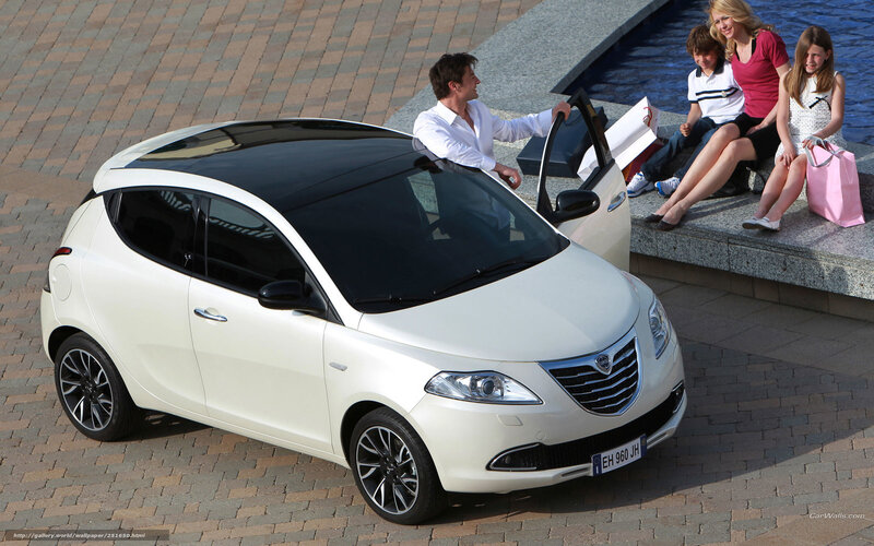 Family with white car by water