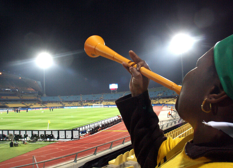 Fan blowing vuvuzela at stadium