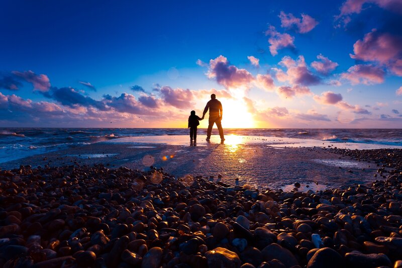 Father and child at sunset on beach