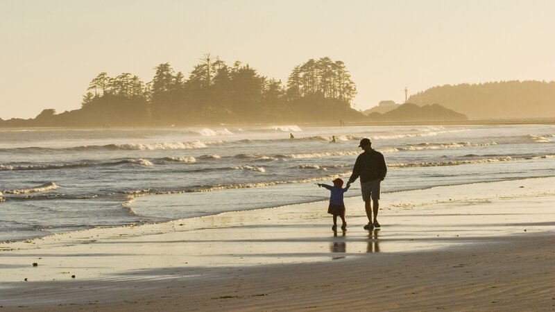 Father and child on beach at sunset