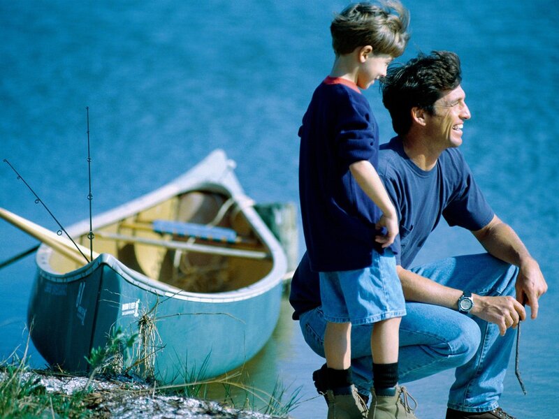 Father and son fishing by a lake