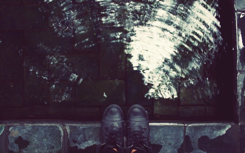 feet in boots on wet pavement