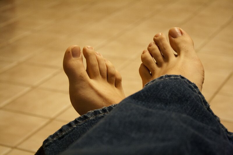 feet in jeans on tiled floor