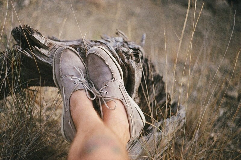feet in shoes on driftwood