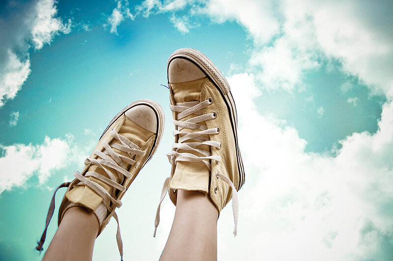 feet in sneakers against sky