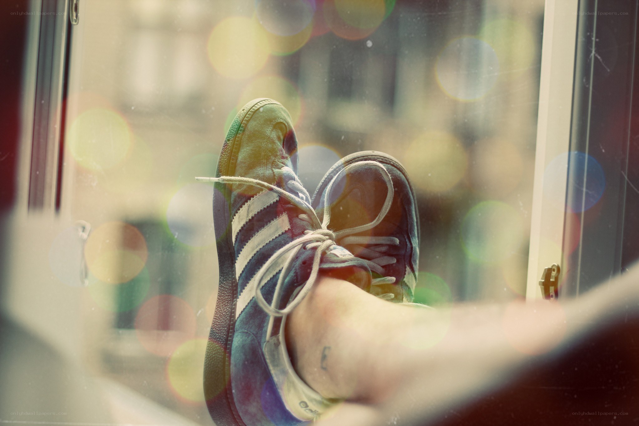 feet in sneakers by window