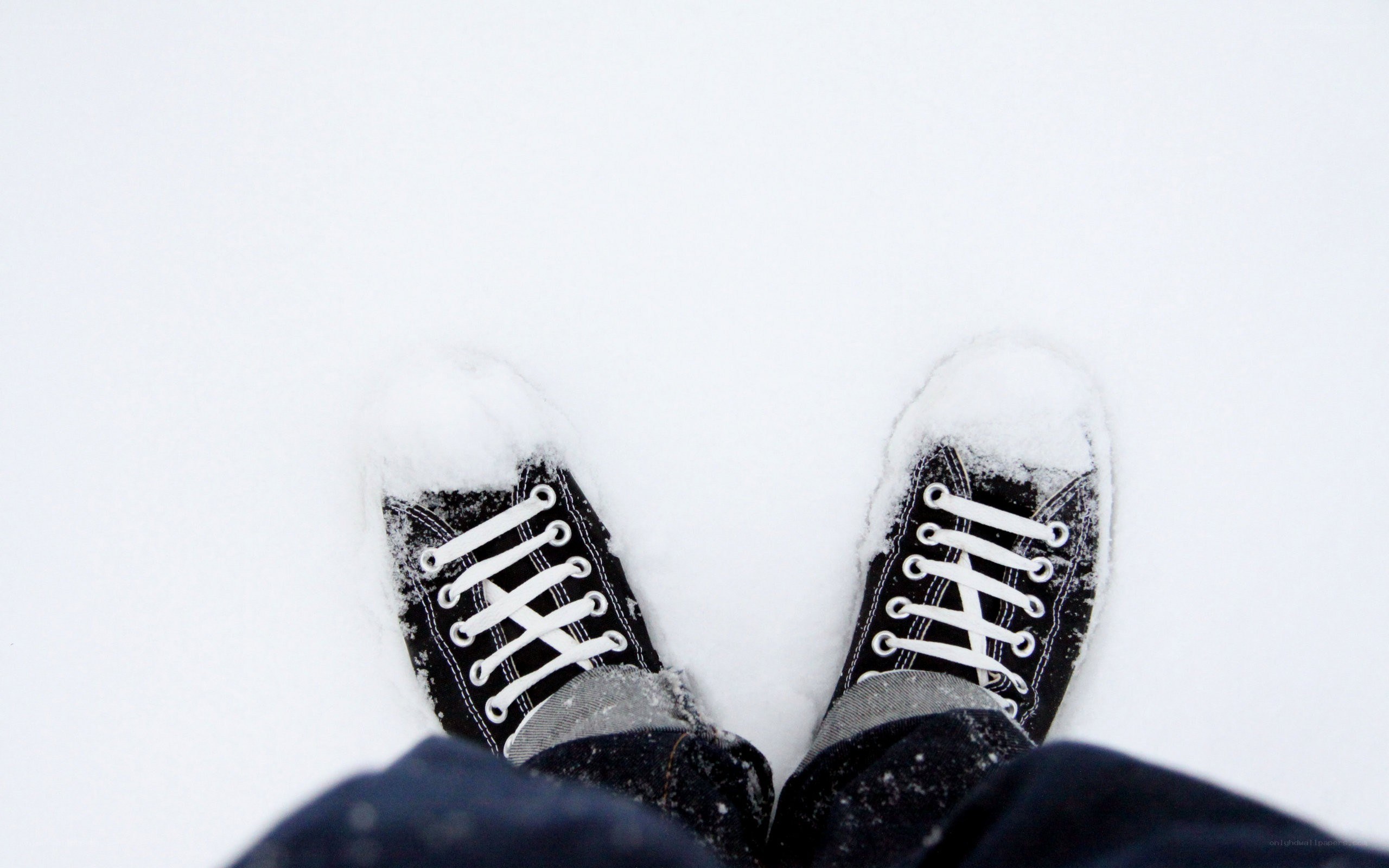 feet in snow-covered sneakers
