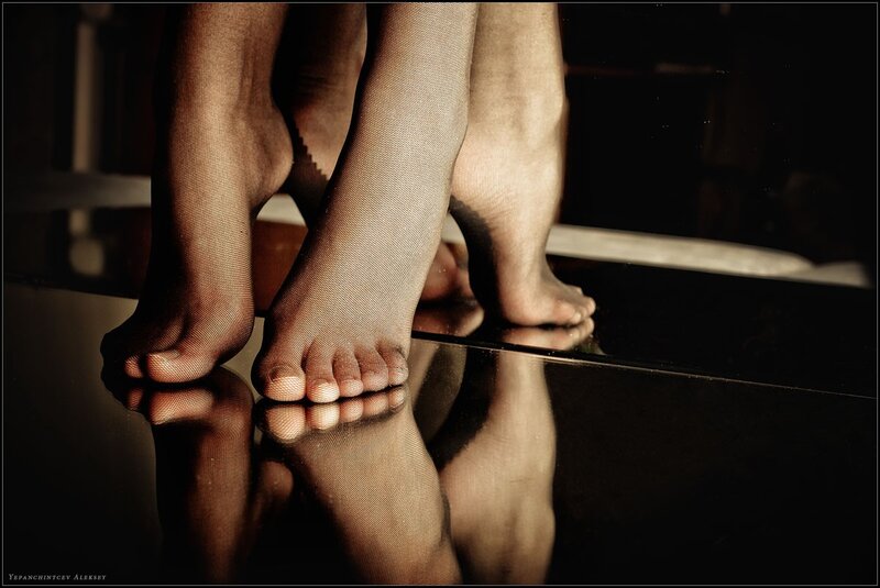 feet in stockings on reflective surface
