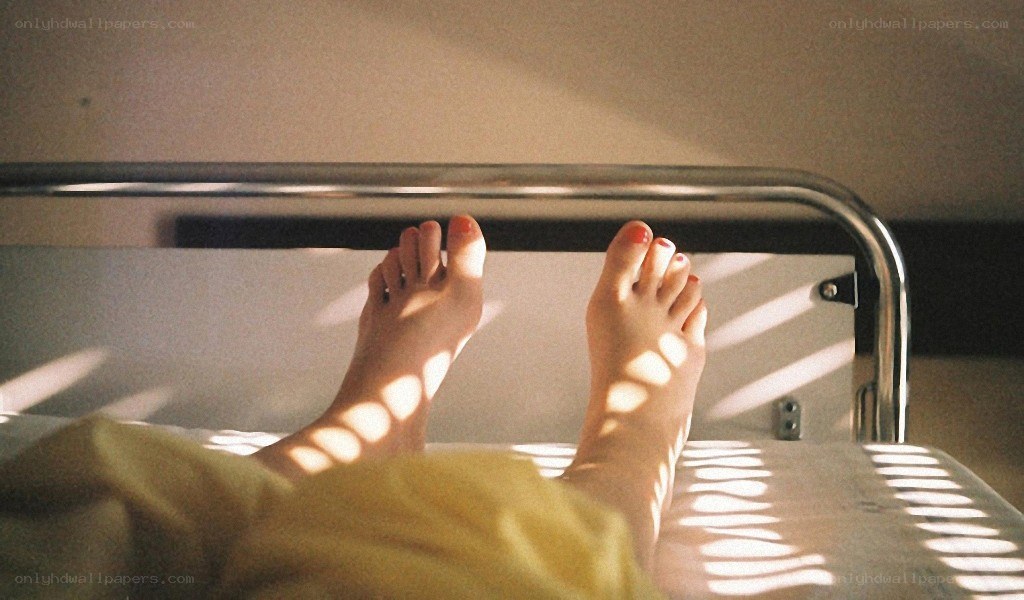 feet in sunlight on bed