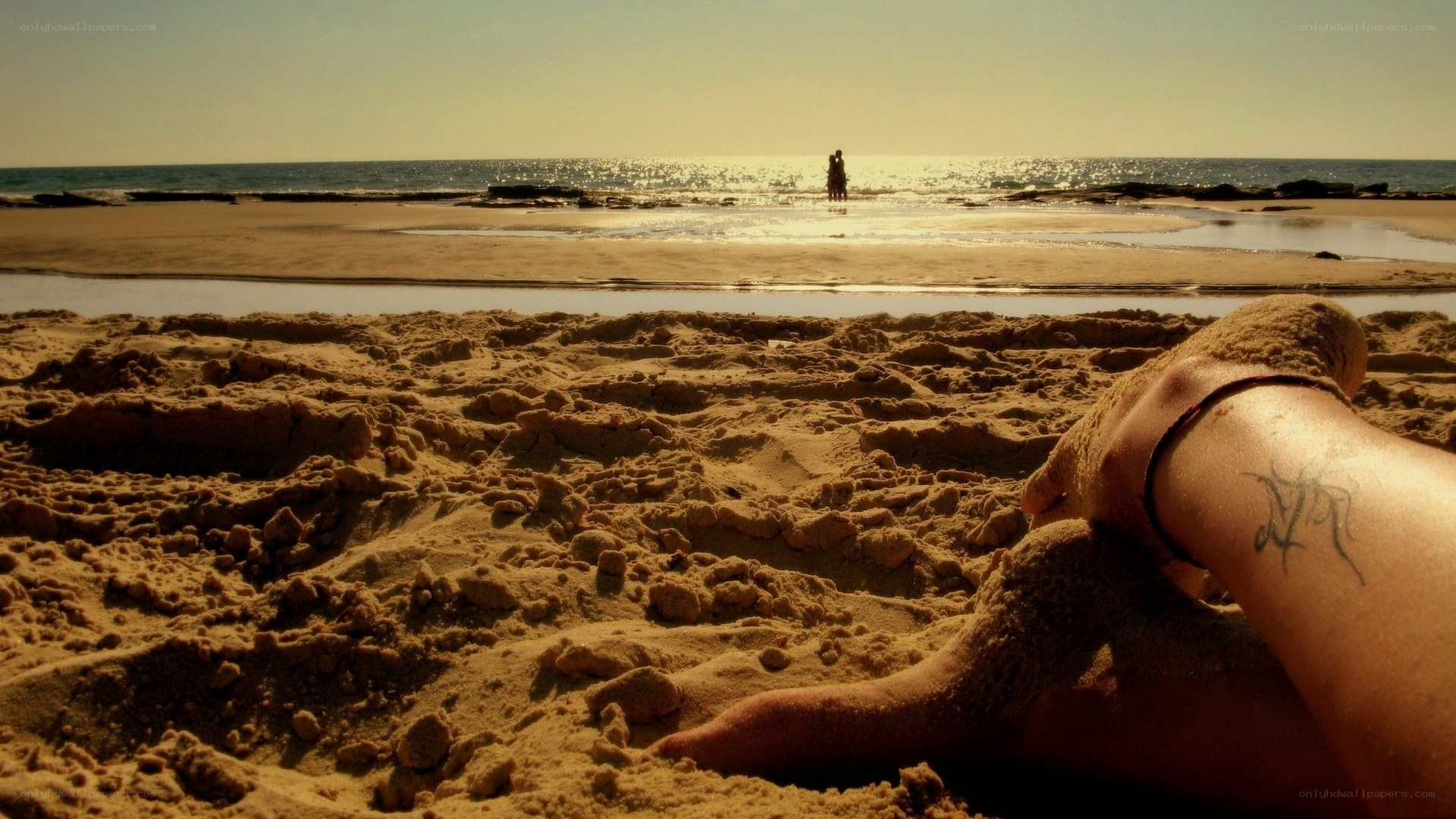 Feet in the sand at sunset